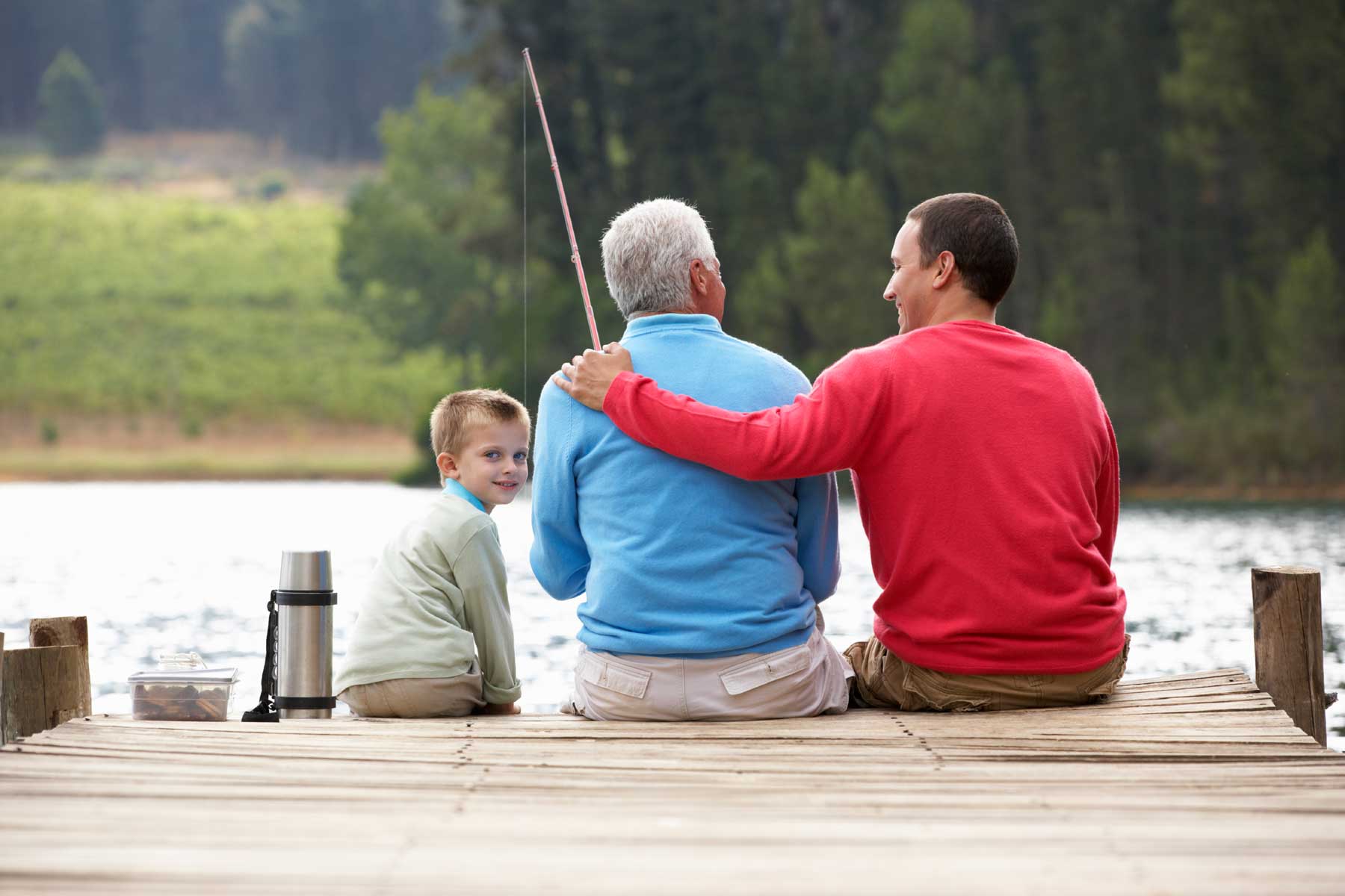 Family sitting on dock fishing