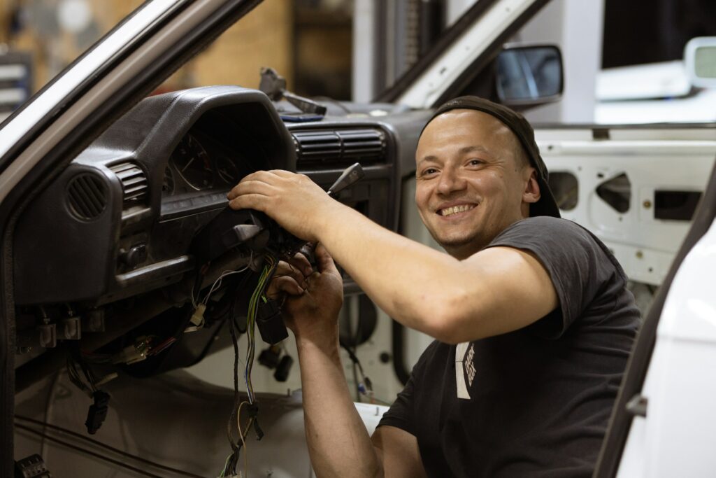 Smiling mechanic inside a vehicle