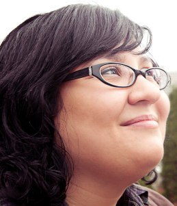 Woman in glasses smiling looking up