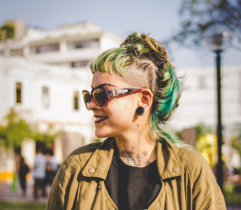 Woman with dyed hair wearing jacket with tattoos